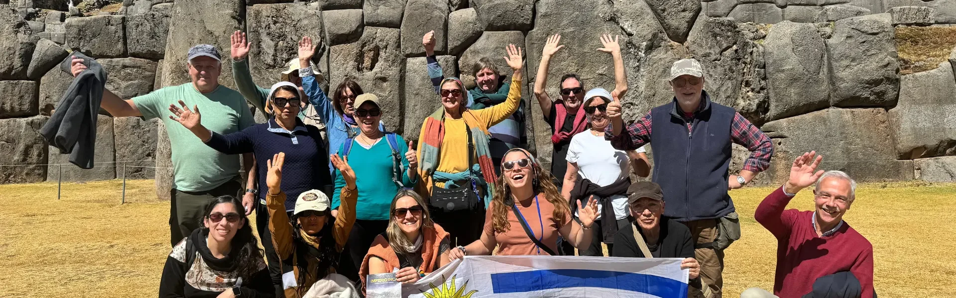 grupo de viajeros de el kaminante posando con la bandera de uruguay